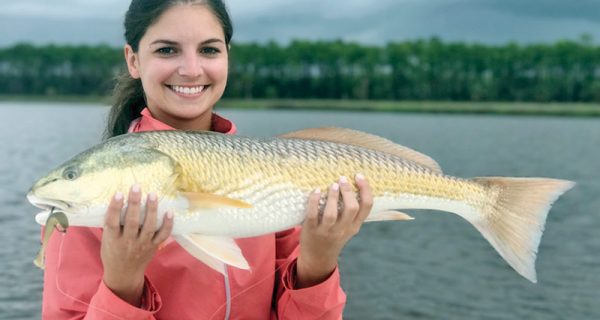 Abbey Posey with a stud 27 inch redfish caught on the new Storm Coastal paddle tail in mullet color.