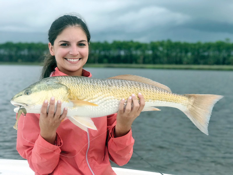 Abbey Posey with a stud 27 inch  redfish caught on the new Storm Coastal paddle tail in mullet color.