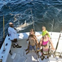 Mindy and kids with a monster lemon shark caught with New Lattitude Sportfishing.