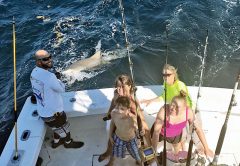 Mindy and kids with a monster lemon shark caught with New Lattitude Sportfishing.