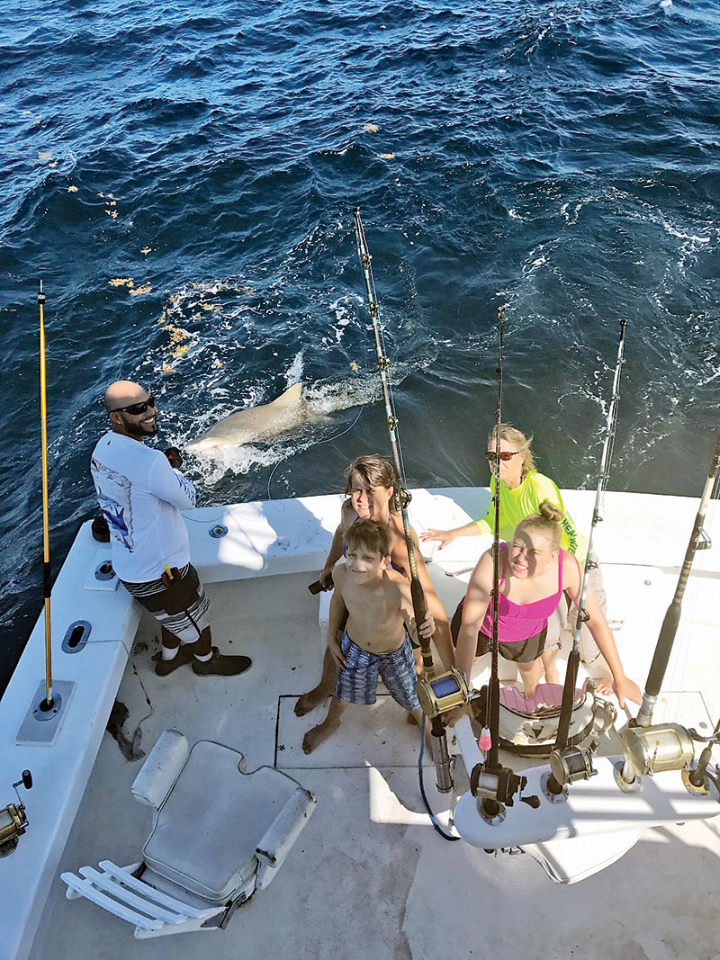 Mindy and kids with a monster lemon shark caught with New Lattitude Sportfishing.