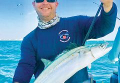 Happy angler with a Spanish mackerel caught aboard Bouncer’s Dusky 33.