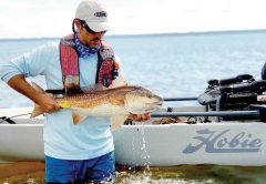 Benton Parrott, paddle power editorial writer, shows off a nice redfish caught from his Hobie kayak.