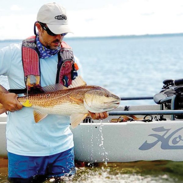 Benton Parrott, paddle power editorial writer, shows off a nice redfish caught from his Hobie kayak.