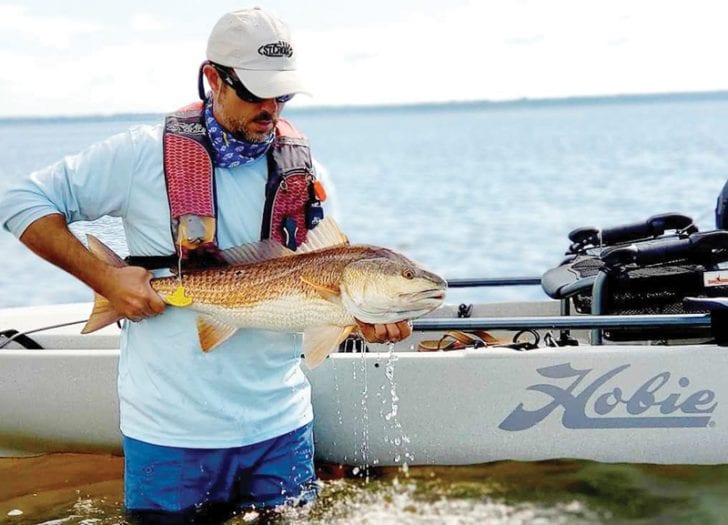 Benton Parrott, paddle power editorial writer, shows off a nice redfish caught from his Hobie kayak.