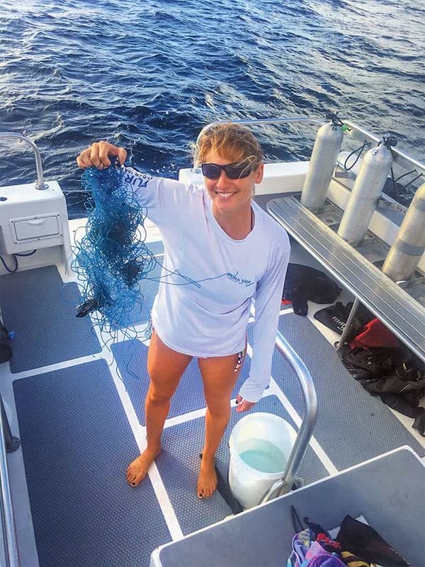 Jamie Cruce holds up tangled fishing line divers removed from a reef.