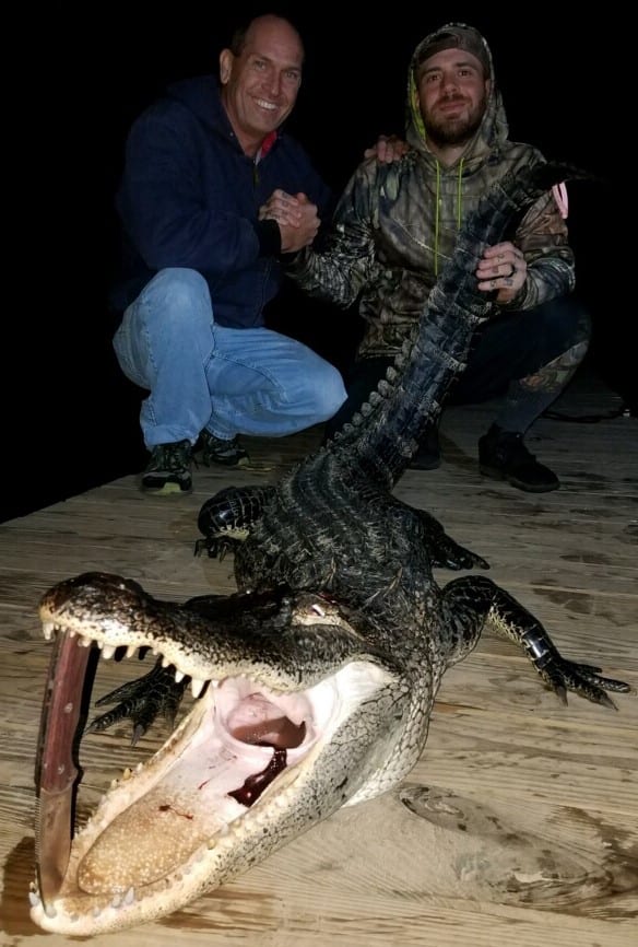 David Meredith (left) and Josh Korel (right) show off a gator they caught on the Escambia River.