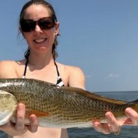 Julia Mahatekar proudly displays her redfish taken on the Eastern Shore of Mobile Bay.