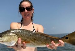 Julia Mahatekar proudly displays her redfish taken on the Eastern Shore of Mobile Bay.