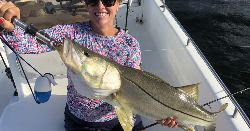 Jackie with a snook caught on a DOA C.A.L. 3” shad tail.