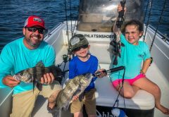 Ryan, Ryker and Ocean holding up black drum.