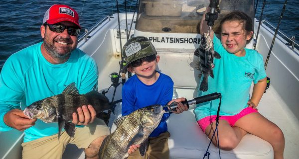 Ryan, Ryker and Ocean holding up black drum.