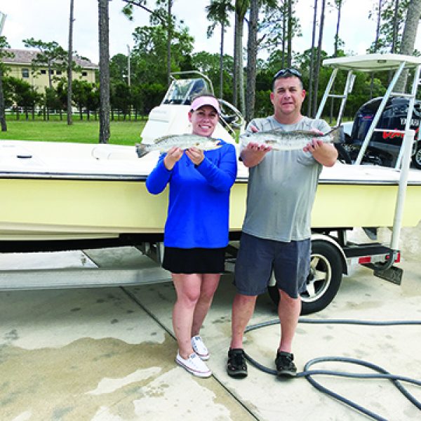 couple with fish in front of trailered boat