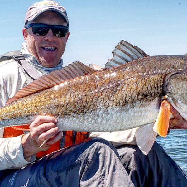 Marty Mood with a bull red while trout fishing the grass flats in Pensacola.