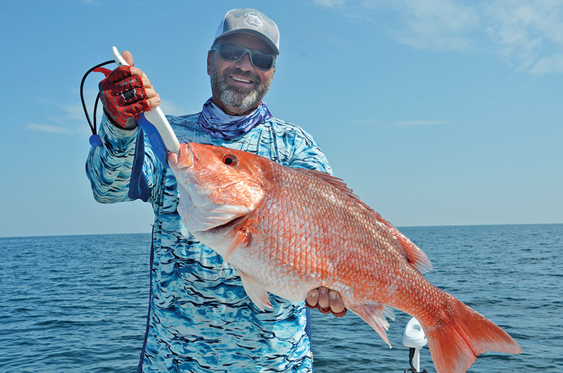 Capt. C-note with a fine snapper caught nearshore with a Speed Drop rig  and a nose-hooked live cigar minnow.