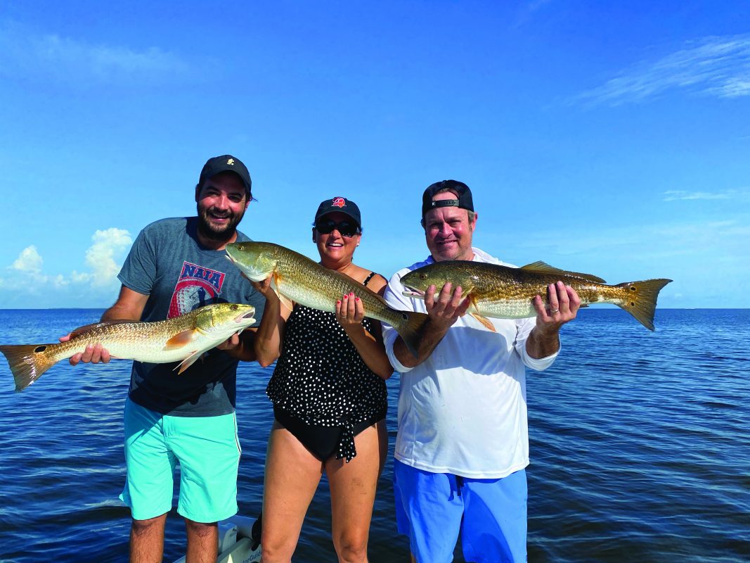 happy-clients-hauling-in-the-redfish-w-matlacha-fishing-charters