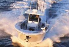 A center console fishing boat with outriggers running fast across the open ocean, leaving a wide white wake