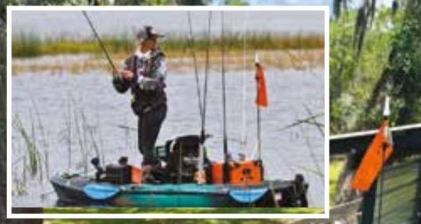 An angler standing and casting from a fishing kayak on a grassy lake, inset over a kayak on a stand loaded with a cooler, a safety flag, a paddle, and gear