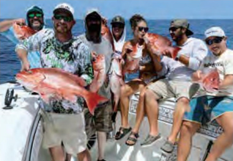 Seven anglers on a boat holding up red snapper caught offshore