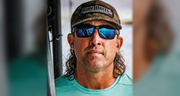 Capt. Daniel Levesque of Rare Breed Charters in a Rare Breed cap, blue mirrored sunglasses and a teal Rare Breed shirt