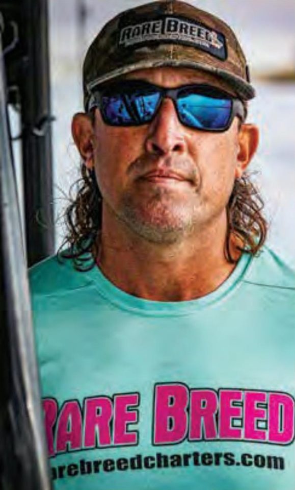 Capt. Daniel Levesque of Rare Breed Charters in a Rare Breed cap, blue mirrored sunglasses and a teal Rare Breed shirt