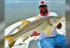 Capt. Marshall Wallot of New Legacy Fishing Charters holding a big snook on his boat