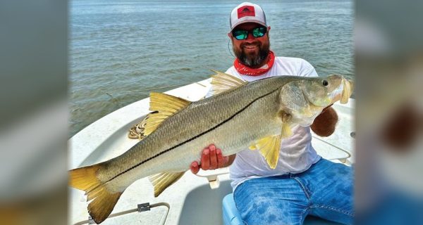 Capt. Marshall Wallot of New Legacy Fishing Charters holding a big snook on his boat
