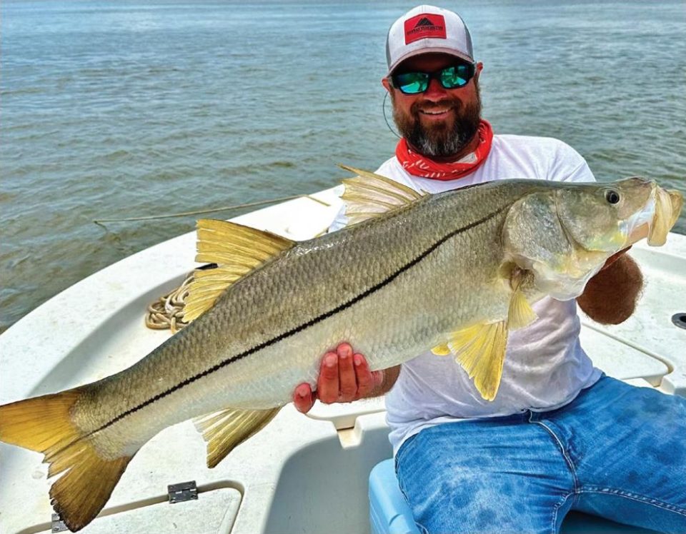 Capt. Marshall Wallot of New Legacy Fishing Charters holding a big snook on his boat