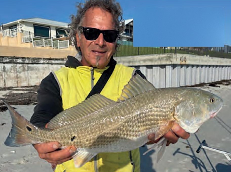 Marco Pompano on the beach holding the redfish he caught by hand line