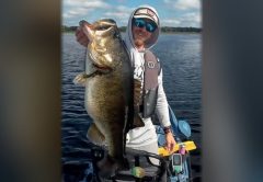 Devin Holbrook holding a big largemouth bass on his kayak