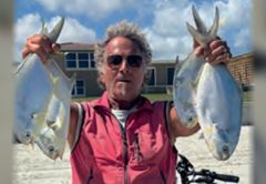 Marco Pompano holding up a pompano in each hand on the beach