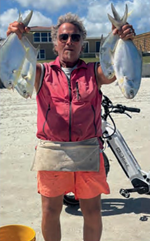 Marco Pompano holding up a pompano in each hand on the beach