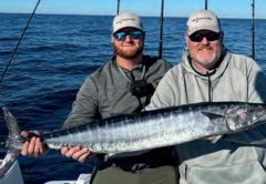Capt. Sean Smith, right, and an angler holding a wahoo offshore