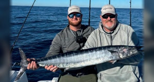 Capt. Sean Smith, right, and an angler holding a wahoo offshore