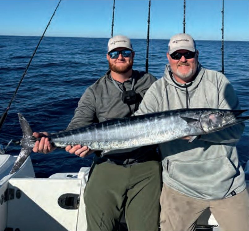 Capt. Sean Smith, right, and an angler holding a wahoo offshore