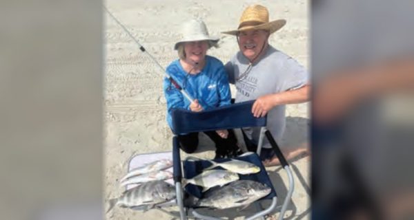 Two anglers on the beach with a catch of pompano, black drum, sheepshead, and whiting