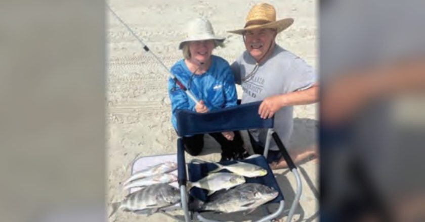 Two anglers on the beach with a catch of pompano, black drum, sheepshead, and whiting