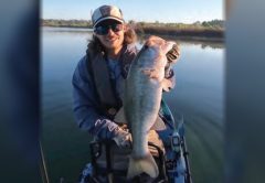 Kayak angler holding a big largemouth bass