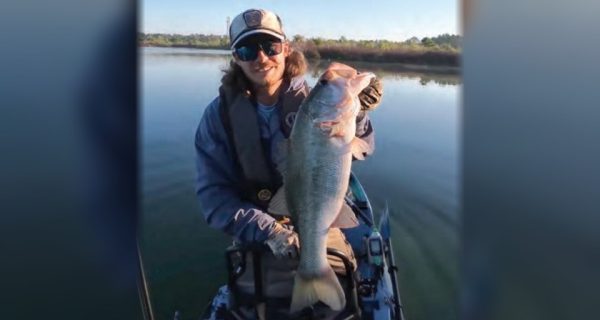 Kayak angler holding a big largemouth bass