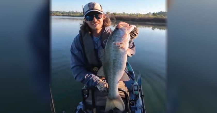 Kayak angler holding a big largemouth bass