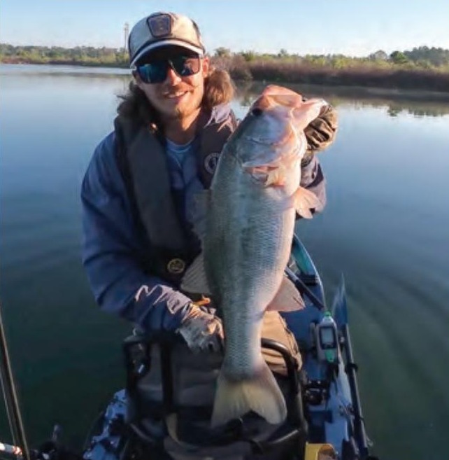 Kayak angler holding a big largemouth bass