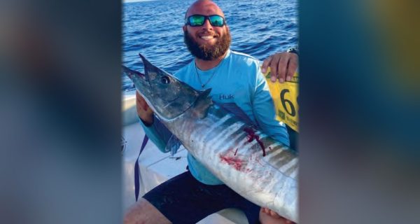 Capt. Nicholas Siciliano of Beast Coast Fishing Charters holding a wahoo on a boat