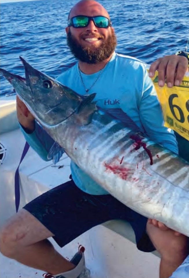 Capt. Nicholas Siciliano of Beast Coast Fishing Charters holding a wahoo on a boat