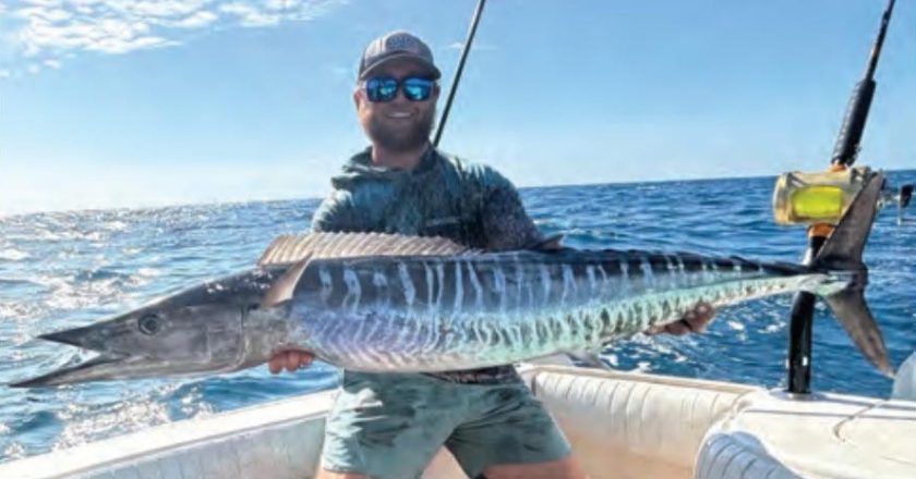 Capt. Kevin Moran of Strippin Lips Fishing Charters holding a wahoo on a boat