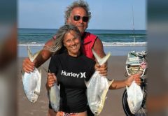 Two anglers holding pompano caught from the surf