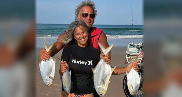 Two anglers holding pompano caught from the surf