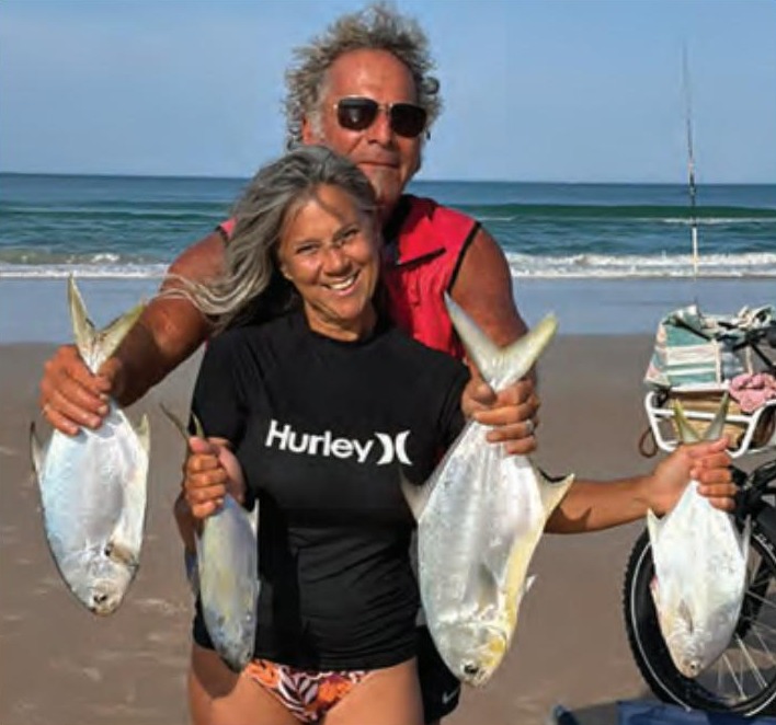 Two anglers holding pompano caught from the surf
