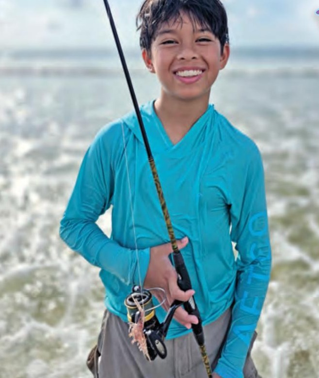 Young angler holding a spinning rod with a popping cork