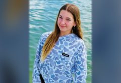 Young angler in a Sol Fishing performance shirt standing in shallow water