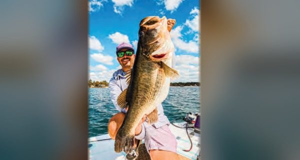 Capt. Tyler Woolcott holding a big largemouth bass